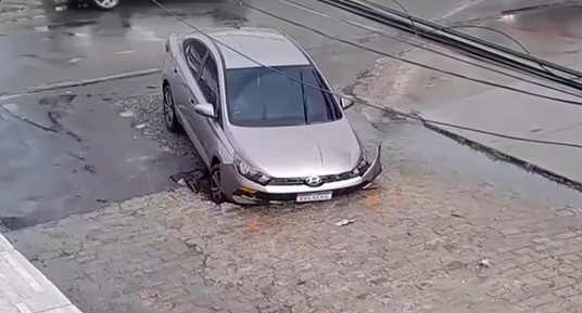 Carro é “engolido” por buraco em rua do Clima Bom